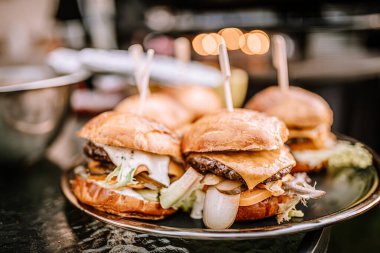 Valmiera, Letonya - 10 Ağustos 2023 - Bir tabak peynirli ve marullu gurme burger.