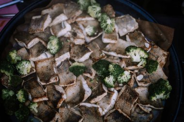 Valmiera, Letonya - 10 Ağustos 2023 - Brokoli çiçekleriyle karıştırılmış balık fileto tepsisi.