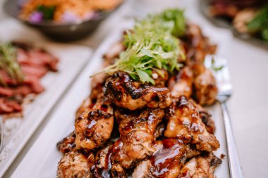 Valmiera, Letonya - 19 Ağustos 2023 - Kapalı kaplama ızgara tavuk servis tabağında taze otlarla süslenmiş.