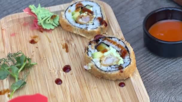 Two Cut Sushi Rolls Presented Wooden Board One Topped Spicy — Wideo stockowe