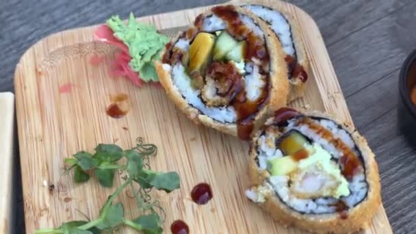 Close Hånd Ved Hjælp Spisepinde Til Tilføje Wasabi Til Sushi – Stock-video