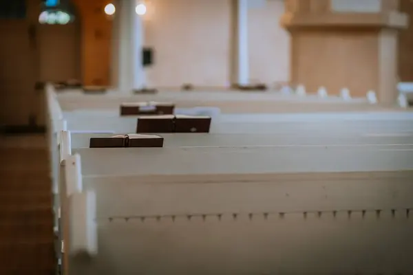 stock image Valmiera, Latvia - May 12, 2024 - Church pews with hymn books in a serene and empty chapel.