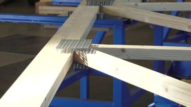 Balvi, Letonya - 25 Mayıs 2024 - Bir atölyede mavi levhaların birleştiği ahşap kirişlere yakın çekim.