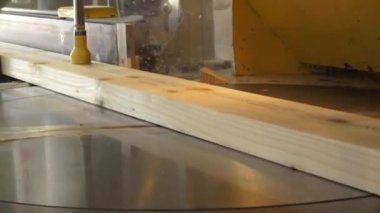 Balvi, Letonya - 25 Mayıs 2024 - Endüstriyel marangozluk makinesinin dairesel testeresi ile kesilen ahşap bir kalasın yakın çekimi.