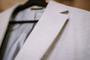 Valmiera, Letonya - 9 Eylül 2023 - Askıda açık gri bir takım elbise ceketi, doku ve kumaş detaylarına odaklanma.