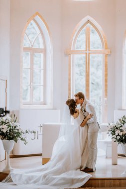 Valmiera, Letonya - 9 Eylül 2023 - Gelin ve damat kilisenin düğün töreninde ilk kez öpüştüler..