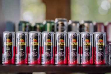 Sigulda, Letonya - 10 Eylül 2023 - Arka planda canlı siyah ve kırmızı ambalajlar sergilenen bir sıra Hamursuz Bayramı tonik kutusu