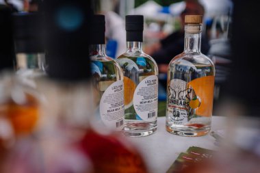 limbazi, Letonya, 29 Haziran 2024 - Ayıcık Sütü Portakal likörü şişeleri açık hava pazarında bir masada sergilendi. Etiketlerde bir ayı ve turuncu çizim yer alıyor..