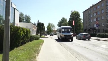 Balvi, Letonya - 28 Mayıs 2024 - Güneşli bir günde Balvi, Letonya 'da bir caddeden geçen bir otobüsün videosu.