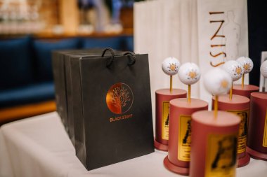 Riga, Letonya 20 Mart 2024 - Siyah Eşyalar hediye çantasının yakın çekimi ve kapalı bir masada golf temalı ödüller. Boşluğu kopyala.