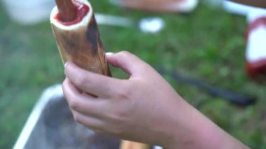 Ekmeğin içinde ızgara sosis tutan, çatalla ketçap ekleyen, açık hava pikniğinde ya da kamp yapan biri..