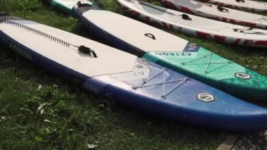 Valmiera, Letonya - 29 Temmuz 2024 - Bir grup şişirilebilir raket çimenlerin üzerine serildi, kullanıma hazır, renkli tasarımlarını ve açık hava düzenlerini vurguladılar.