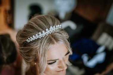 Cesis, Latvia - July 12, 2024 - A close-up of a bride's head, showcasing her elegant updo hairstyle adorned with a sparkling crystal tiara, capturing the details of her wedding preparation. clipart