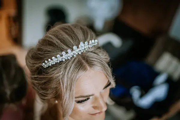 stock image Cesis, Latvia - July 12, 2024 - A close-up of a bride's head, showcasing her elegant updo hairstyle adorned with a sparkling crystal tiara, capturing the details of her wedding preparation.