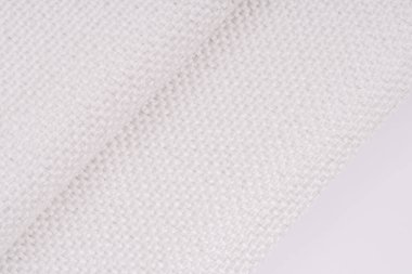 Görünür metal ipliklerle örülmüş beyaz dokuma kumaş, katlanmış kısımları ve karmaşık dokuyu gösteriyor. Resim dokuma desenini vurgular.