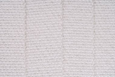 Görünür metal ipliklerle örülmüş beyaz dokuma kumaş, katlanmış kısımları ve karmaşık dokuyu gösteriyor. Resim dokuma desenini vurgular.