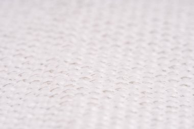 Görünür metal ipliklerle örülmüş beyaz dokuma kumaşın yakın çekimi, makro görünümde karmaşık dokuyu ve deseni vurguluyor.