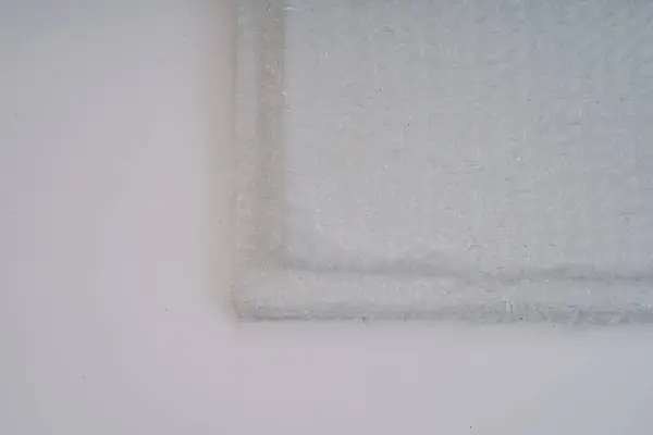 stock image Close-up of overlapping fiberglass mats on a white background, showing the fibrous texture and detail.