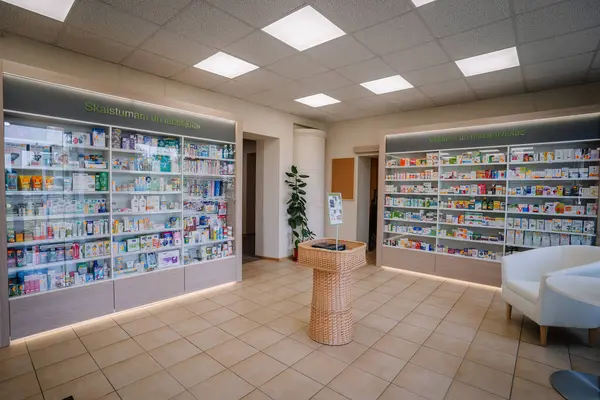 Ilukste, Letonya - 10 Eylül 2024 - Parlak ışıklandırma ve temiz tasarım içeren sağlık, güzellik, vitaminler ve sağlık ürünleri sergilenen modern bir eczane.