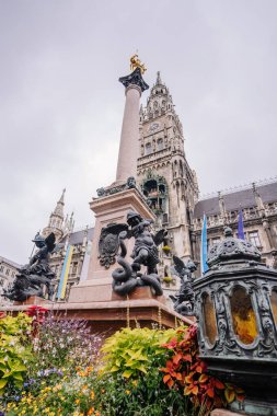 Münih, Almanya - 13 Eylül 2024 - Münih Yeni Belediye Binası ve Mariensule, yağmurlu bir günde Marienplatz 'da Gotik mimariyi sergileyen bir grup turistle birlikte