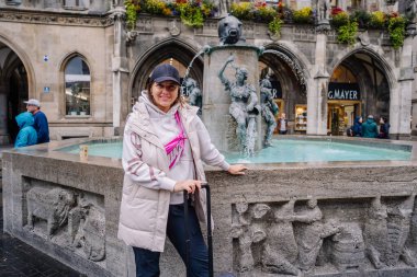 Münih, Almanya - 13 Eylül 2024 - Münih Yeni Belediye Binası ve Mariensule, yağmurlu bir günde Marienplatz 'da Gotik mimariyi sergileyen bir grup turistle birlikte