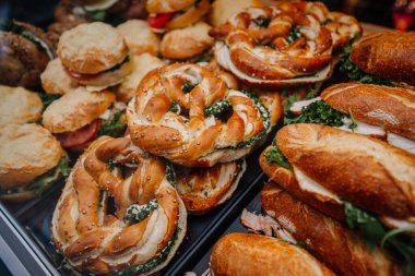 Münih, Almanya - 13 Eylül 2024 - çeşitli Bavyera usulü sandviçler, krem peynirli krakerler ve taze ekmek ruloları, tepside sergilenmektedir.