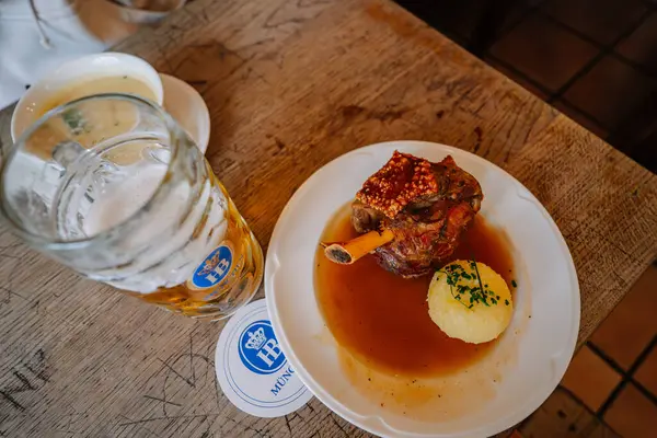 Münih, Almanya - 13 Eylül 2024 - Almanya 'nın Münih kentinde Hofbrauhaus' ta sunulan ahşap bir masada servis edilen geleneksel bir Bavyera yemeğine yakın çekim.