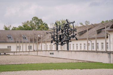 Münih, Almanya - 13 Eylül 2024 - Almanya 'daki Dachau Toplama Kampı Anıtı' nda tutsakların çektiği acıları temsil eden heykel. Binalar arka planda görünür..