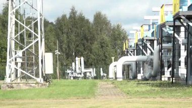 Sigulda, Letonya - 10 Ağustos 2024 - Büyük beyaz boru hatları, metal yapıları ve yeşil çevresi olan açık hava sanayi tesisi. Arazi ormanlık bir alanla çevrili..