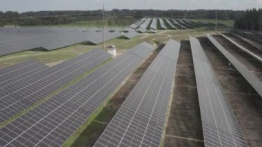  Yeşil alanlar boyunca uzanan geniş bir güneş çiftliğindeki sıra sıra güneş panelleri yenilenebilir enerji üretiyor. Yüksek kalitede s-log ve 4K ile yakalandı.