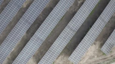 Güneş panellerinin geometrik desenli sıralarının hava görüntüsü yenilenebilir enerji üretiyor. Yüksek kalitede s-log ve 4K ile yakalandı.