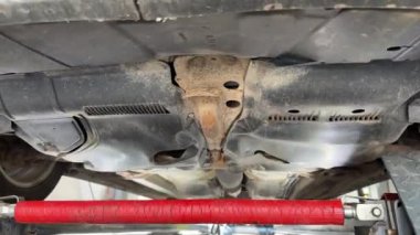 Valmiera, Letonya - 13 Eylül 2024 - Teknik inceleme sırasında bir arabanın altında araç kaldırıldı, denge için kontrol edildi, sarsıntı ya da sorun olmadığından emin olmak için sallandı.