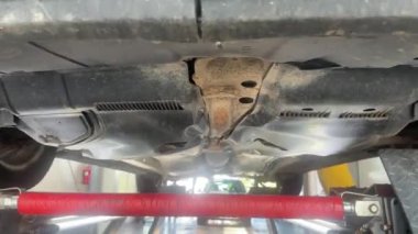 Valmiera, Letonya - 13 Eylül 2024 - Teknik inceleme sırasında bir arabanın altında araç kaldırıldı, denge için kontrol edildi, sarsıntı ya da sorun olmadığından emin olmak için sallandı.