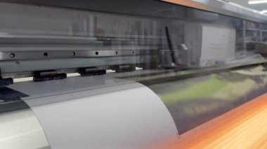 Valmiera, Letonya - 11 Ağustos 2024 - Profesyonel bir matbaadaki geniş bir rulo kağıda resim basan geniş formatlı bir yazıcı.