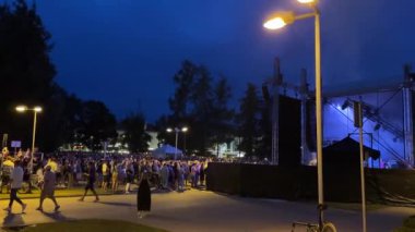 Valmiera, Letonya - 23 Temmuz 2024 - Sokak lambaları altında açık hava konseri için büyük bir kalabalık toplandı..