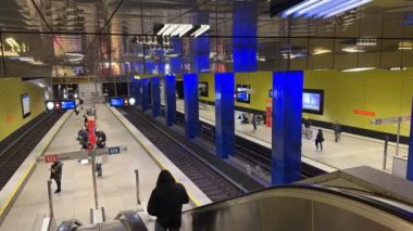 Münih, Almanya - 15 Eylül 2024 - Münih metro istasyonunda yolcuların hareket ettiği, U3 ve U6 hatlarında trenler sergilendiği ve parlak mavi sütunların bulunduğu modern bir Münih metro istasyonunun zamanlaması.