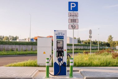 Valmiera, Letonya - 8 Ağustos 2024 - Elektrikli taşıt şarj istasyonu açık yeşil bir alanda, 160 kW 'a kadar hızlı şarj edilebilir..