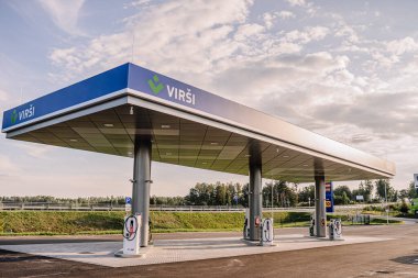 Valmiera, Letonya - 8 Ağustos 2024 - Bulutlu bir gökyüzünün altında geniş ve temiz bir açık alanda bulunan, yakıt pompalarını kapsayan geniş bir VIRSI benzin istasyonu.