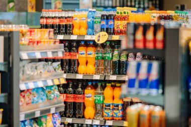 Valmiera, Letonya - 8 Ağustos 2024 - Coca-Cola, Fanta, Sprite ve Pepsi gibi çeşitli şişelenmiş içecekleri iyi aydınlatılmış bir markette sergileyen bir mağaza.