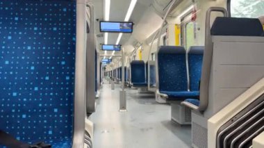 Münih, Almanya - 15 Eylül 2024 - Mavi koltuklu ve bilgi ekranlı boş tren içi, temiz, modern ve ferah bir toplu taşıma ortamı gösteriyor.