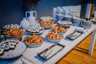 Valmiera, Letonya - 18 Ekim 2024 - yapay zeka konferansı. Çeşitli hamur işleri, kekler ve kahve fincanlarıyla bir masa seti, bir etkinliğe ya da toplanmaya hazır..