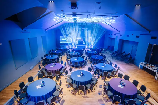 Valmiera, Letonya - 18 Ekim 2024 - yapay zeka konferansı. Yuvarlak masalar ve sahne ışıklarıyla bir konferans salonu, sunumlar ve konuşmalar için hazır..