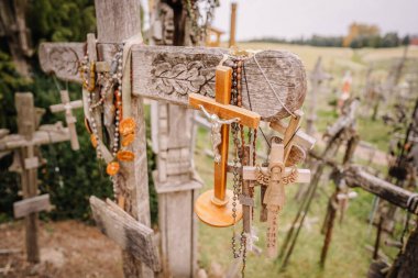 Siauliai, Lithuania, October 21, 2024 Kryi kalnas. Wooden crosses adorned with rosaries and religious symbols at Kryzi Kalnas (Hill of Crosses) in iauliai, Lithuania, a site of pilgrimage and devotion. clipart