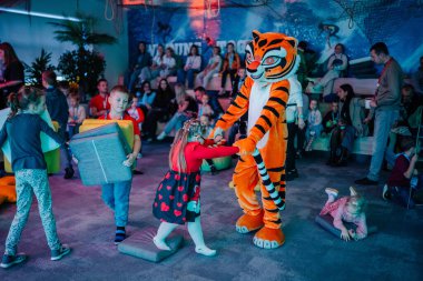 Riga, Letonya - 25 Ekim 2024 - Çocuklar PITER PAN Party 'de oynarlar, kaplan maskotu ve köpük bloklarıyla etkileşime girerler, diğerleri ise eğlenceli aktiviteleri izler ve katılırlar.