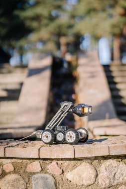 Taş basamaklara yerleştirilmiş engebeli bir teftiş robotu, hareket kabiliyetini ve açık hava ve dengesiz araziye uygunluğunu vurguluyor..