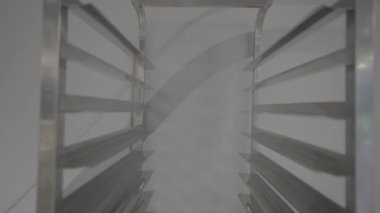 Tekerleklerdeki metalik rafların yakın görüntüsü çizgili gölgeler oluşturarak endüstriyel ve geometrik bir görünüm yaratıyor..
