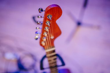 Akort mandallı bir gitar başlığının yakın çekimi, mor ışıklı arka plana yumuşak bir odak ile kaydedildi. Müzik veya enstrüman temaları için ideal.