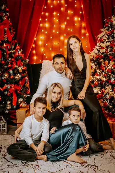 Noel ağaçları, ışıklar ve dekorasyonlarla dolu sıcak bir aile portresi, beraberlik ve tatil ruhu sergileniyor..