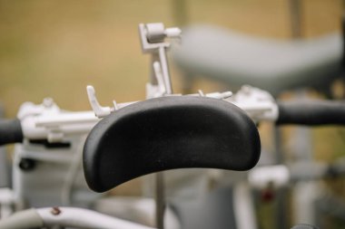 Close-up of a black cushioned headrest on medical equipment, blurred background, showing details of healthcare or mobility device in use. clipart