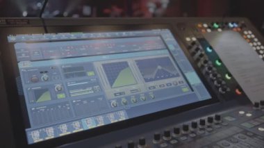 Valmiera, Letonya - 18 Kasım 2024 - Canlı bir olay ayarında ses ayarları, grafikler ve kontrolleri gösteren profesyonel bir ses karıştırma konsolunun yakın çekimi.